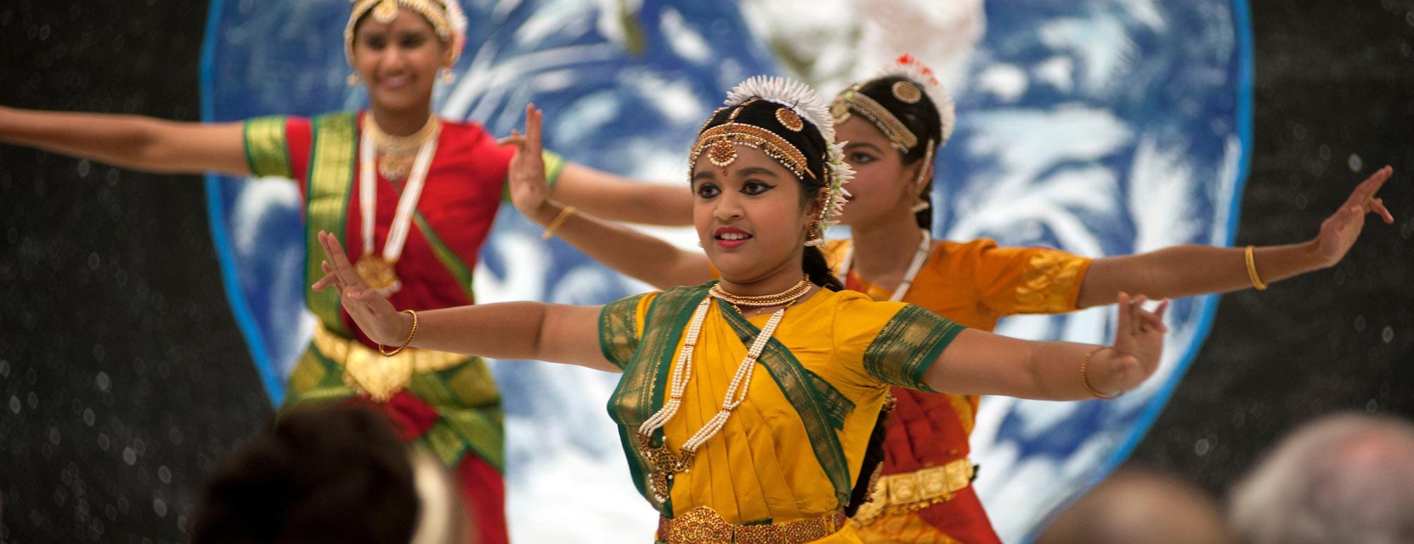 A group of young women preform a South Asian style dance